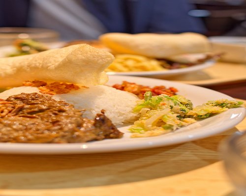 A plate of traditional Indonesian food with plenty of vegetables